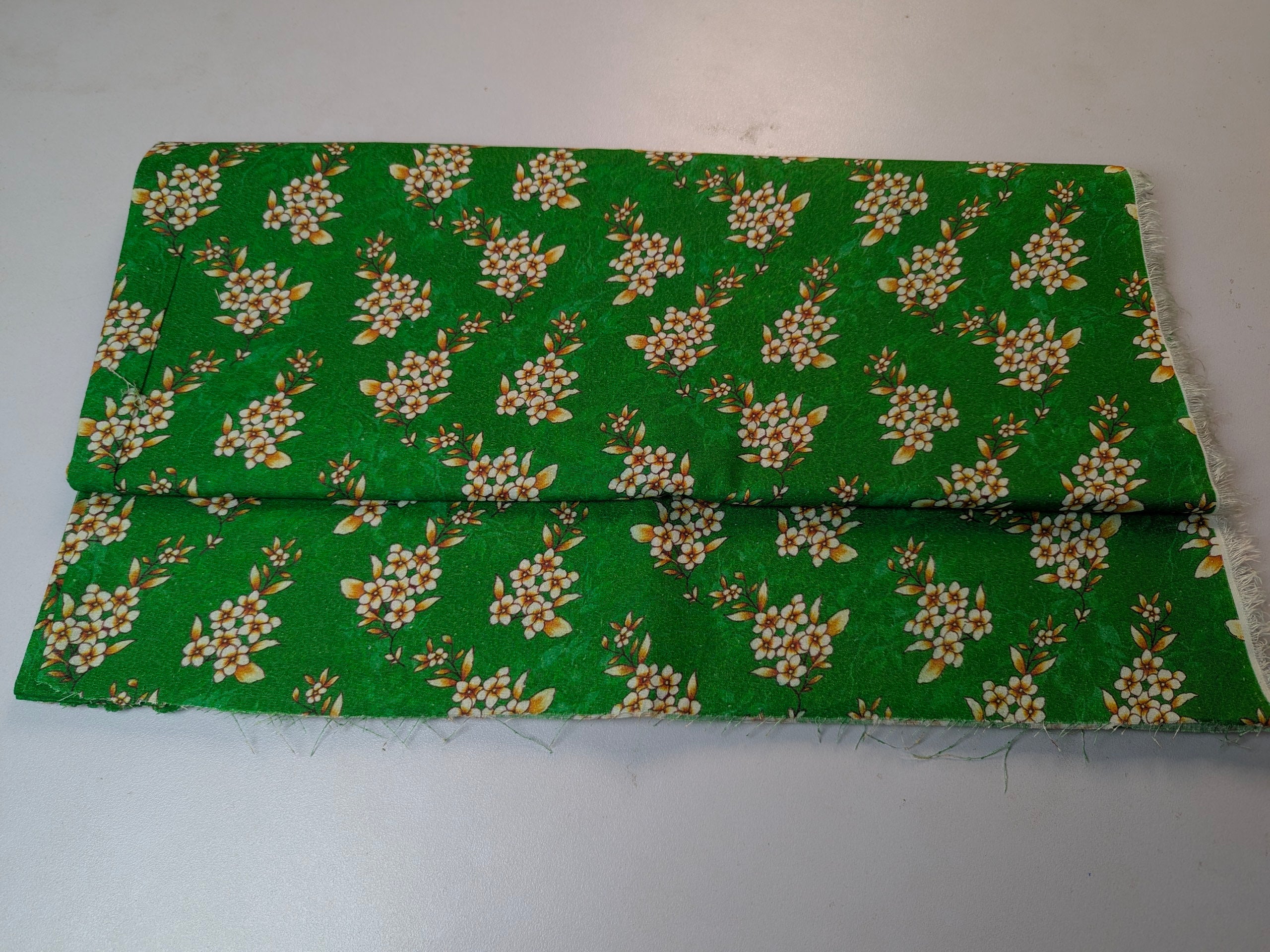 Green fabric with floral pattern on a white background