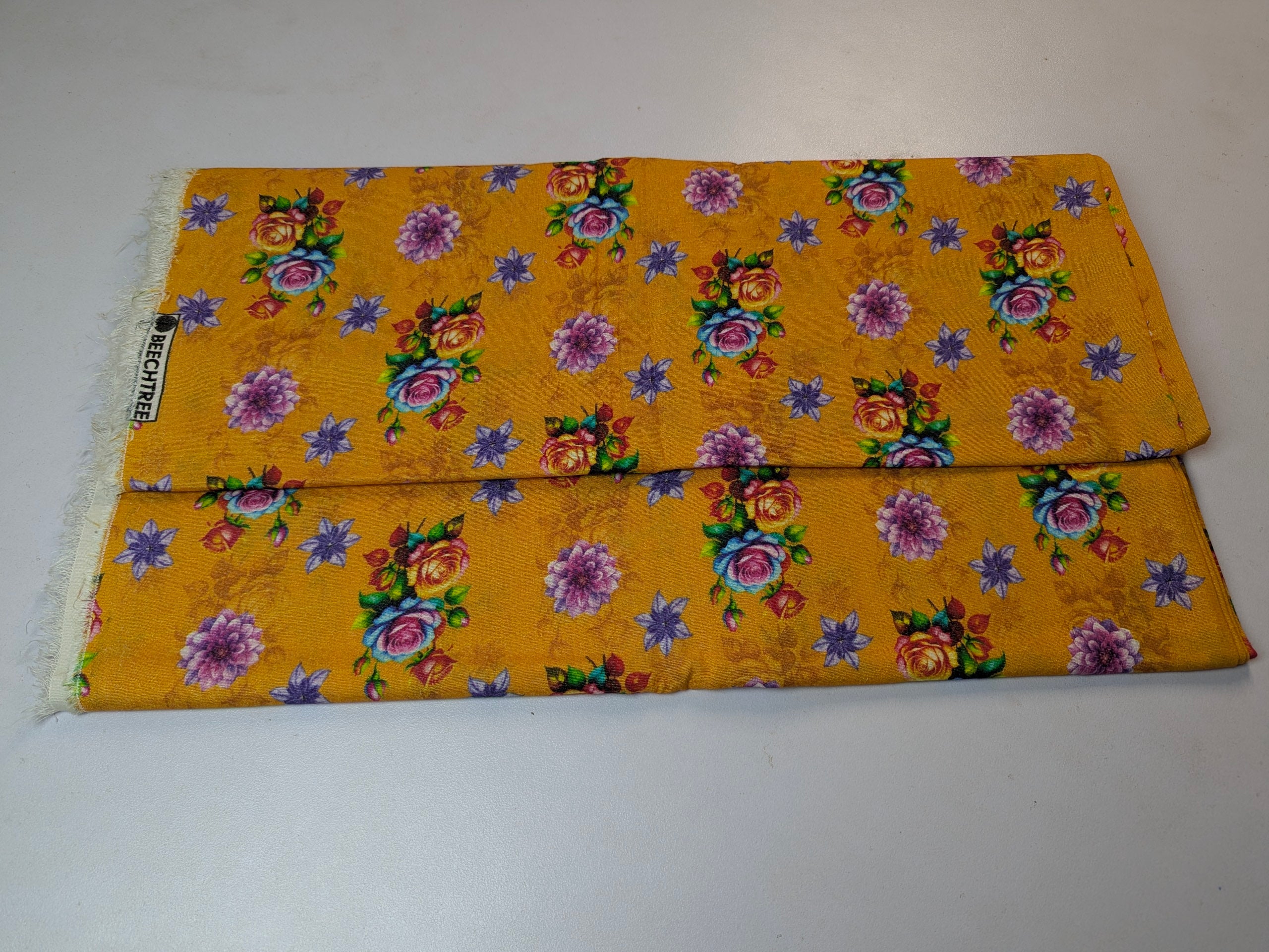 Yellow fabric with floral patterns on a white background