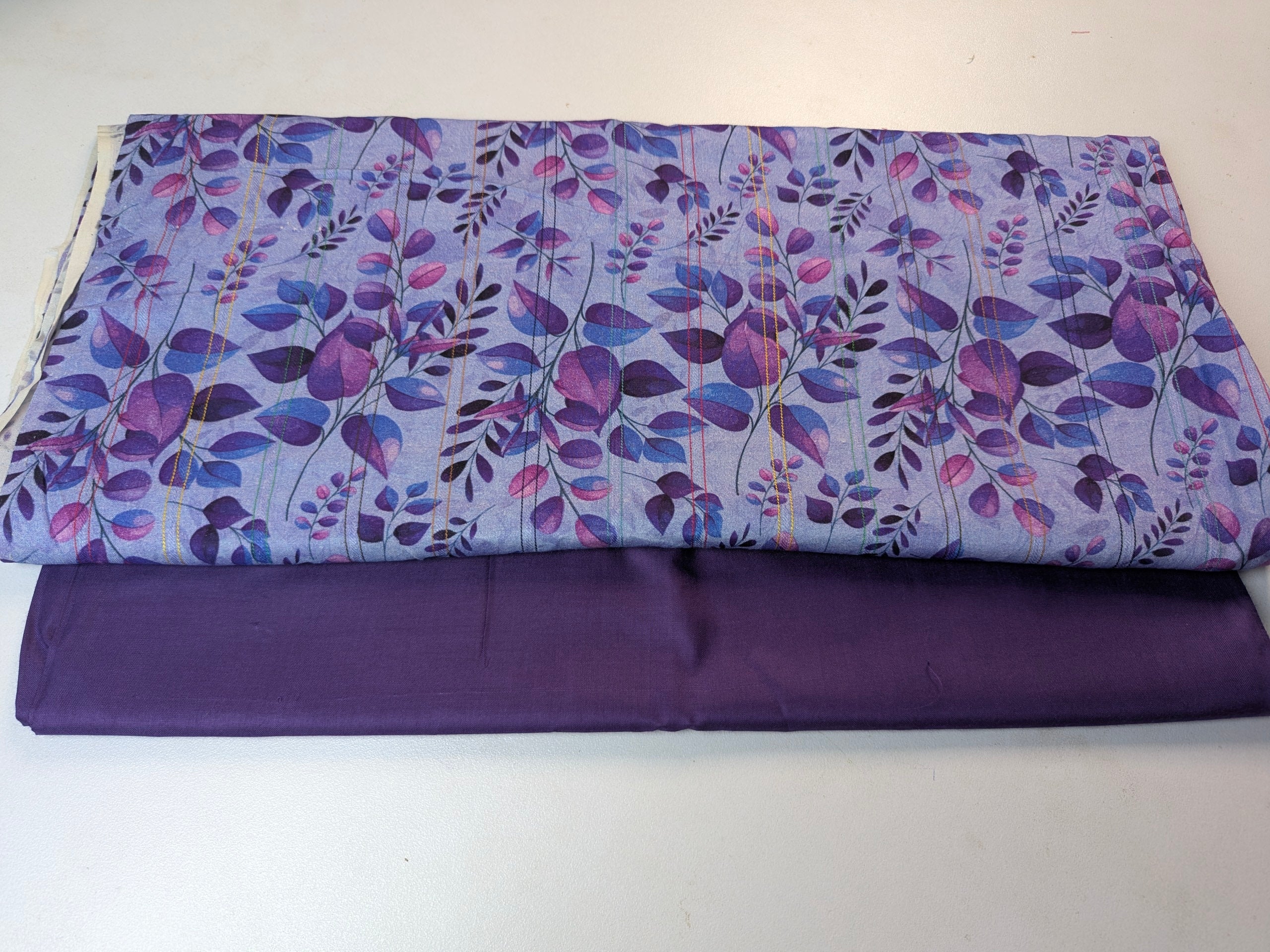 Floral-patterned fabric roll on a white background