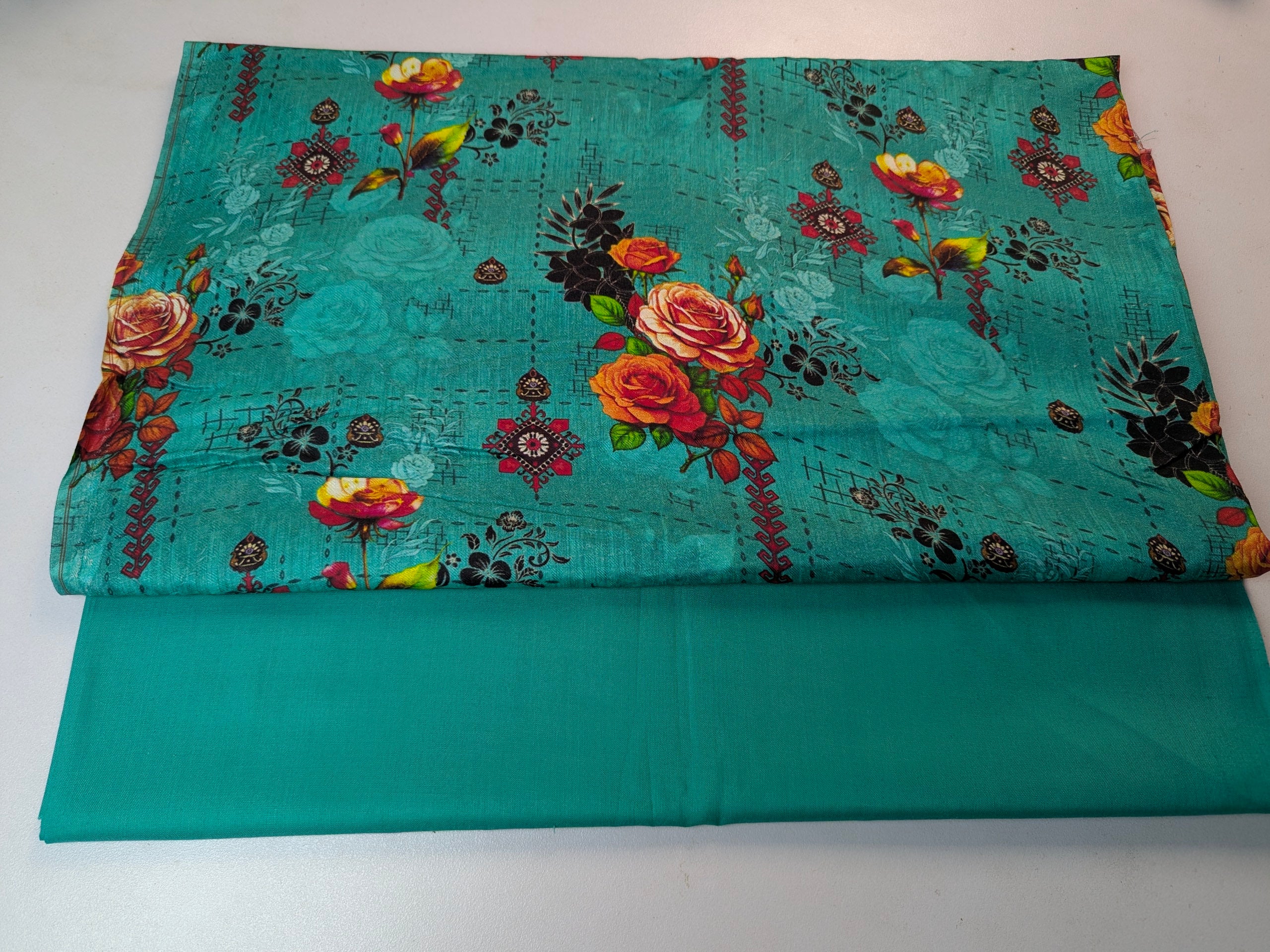 Teal fabric with floral pattern on a white background