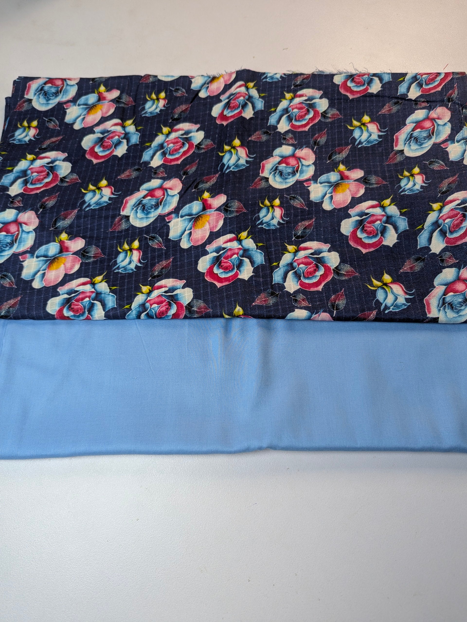 Floral-patterned fabric with a blue border on a white background