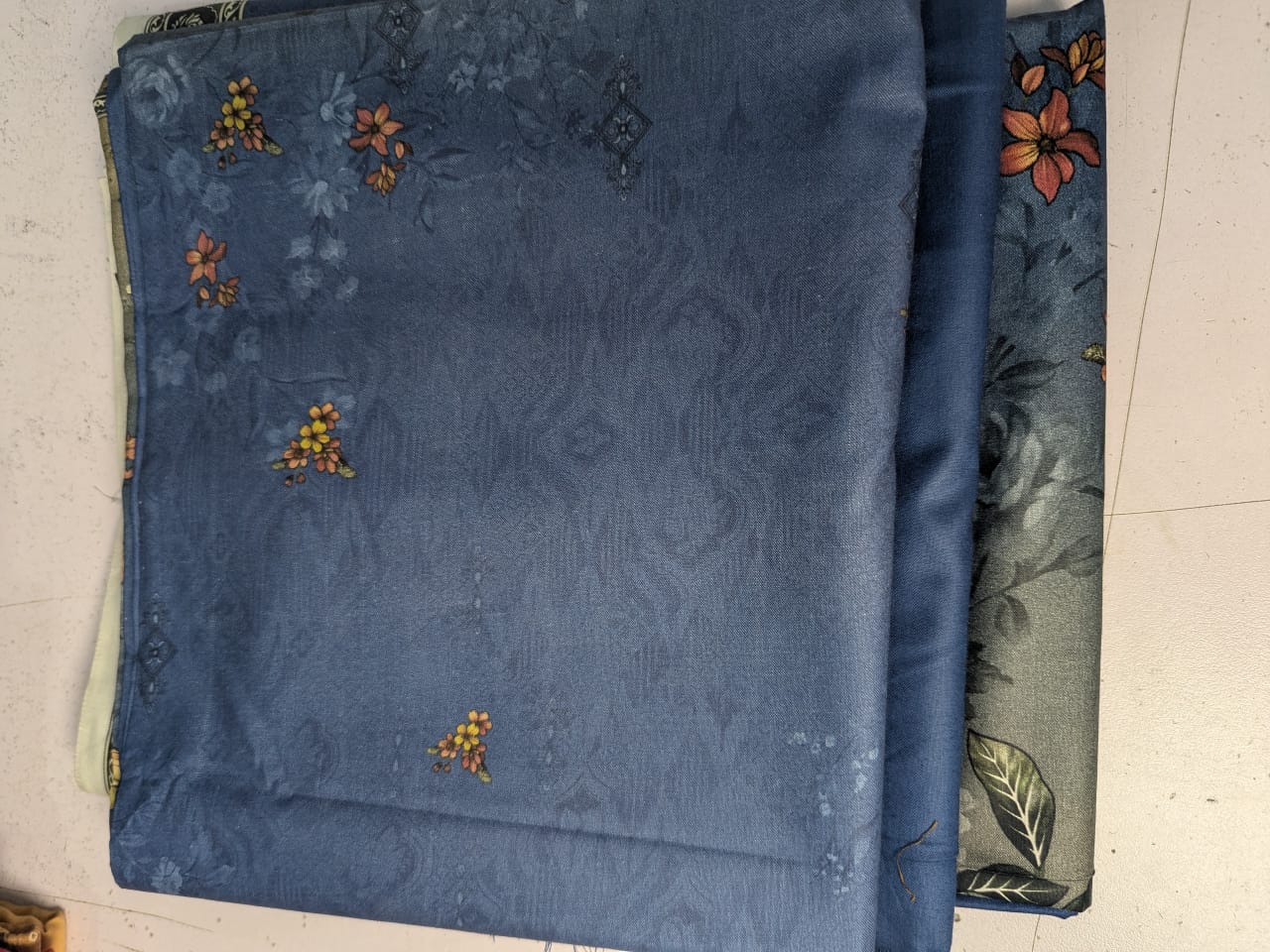 Blue fabric with floral patterns on a tiled floor